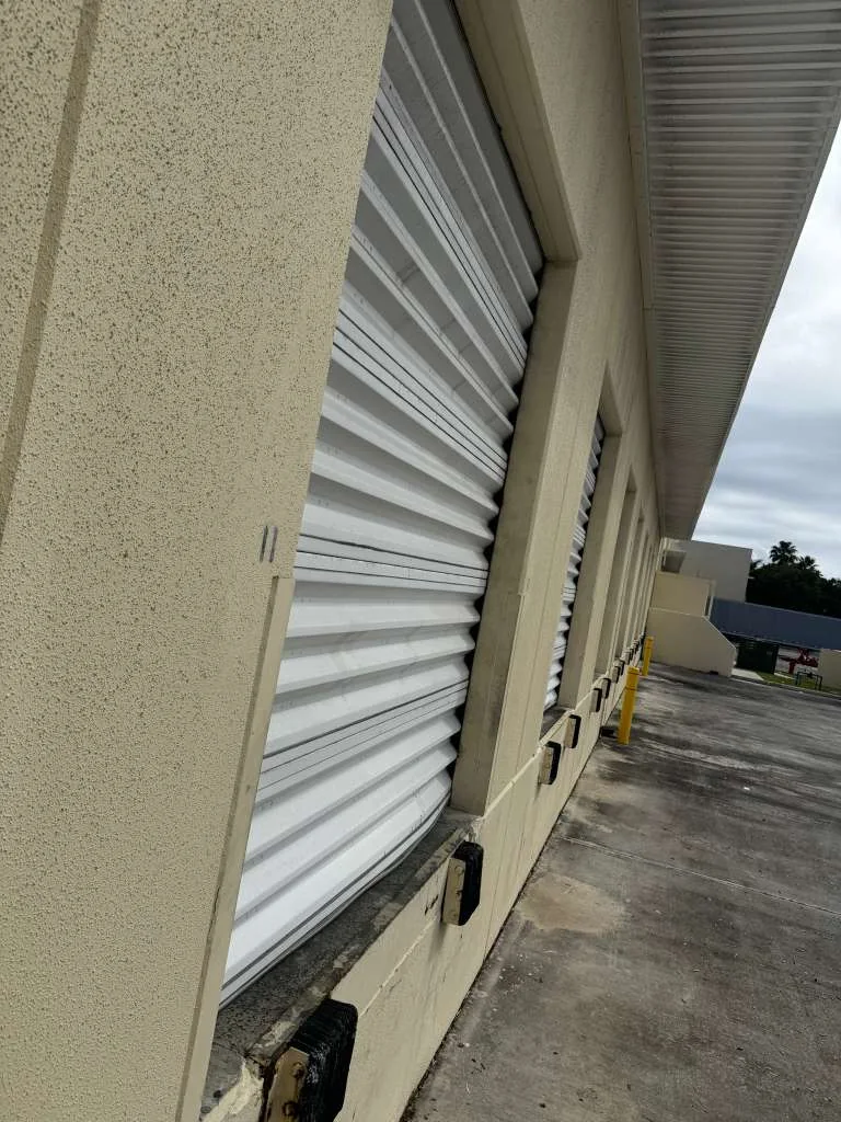 Exterior commercial loading dock roll-up door with bent slats from vehicle impact damage