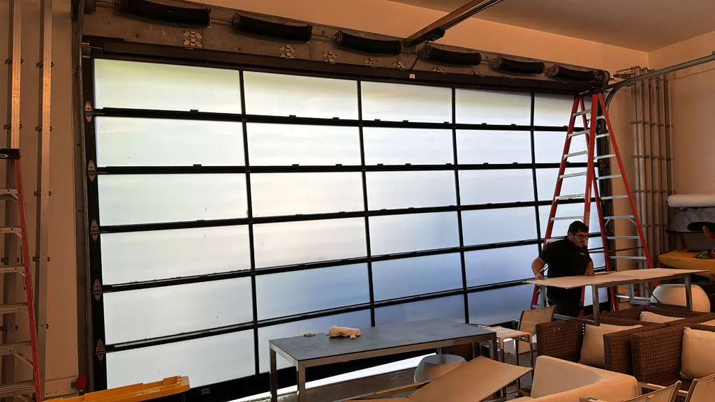 Modern full-view black aluminum and frosted glass garage door installation