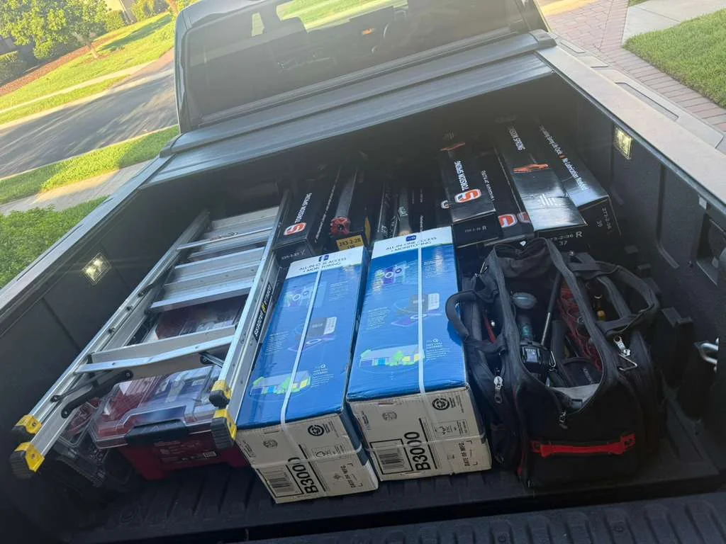 Quick Springs Garage service vehicle loaded with torsion springs, garage door openers, and field tools