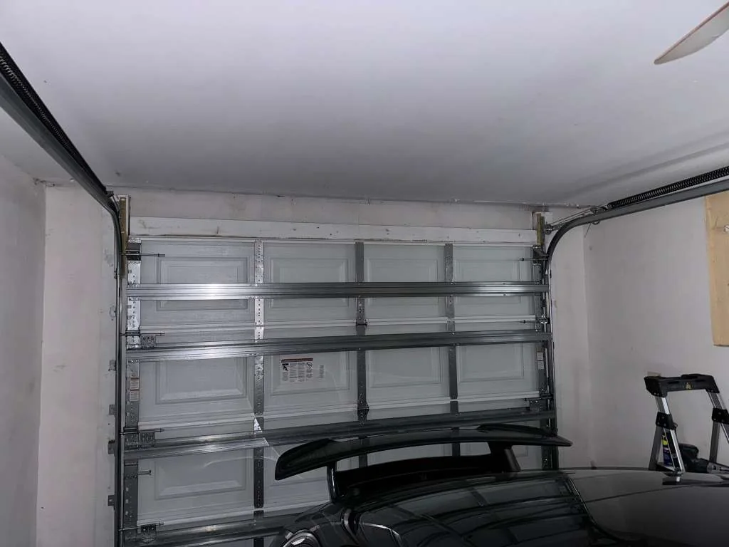 Reinforced hurricane strut garage door panels and heavy-duty hinges above sports car inside garage
