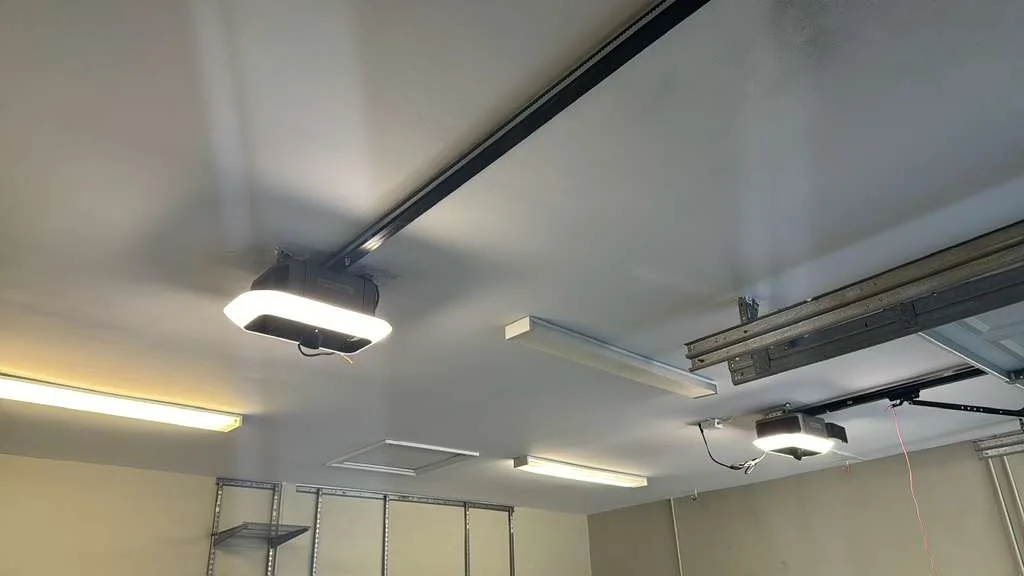 Dual LiftMaster ceiling-mounted garage door openers with integrated LED lighting in modern finished garage