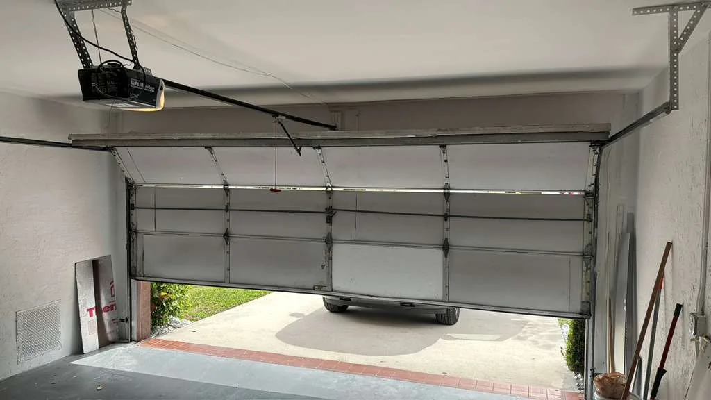 Residential garage door jammed at severe diagonal angle off track