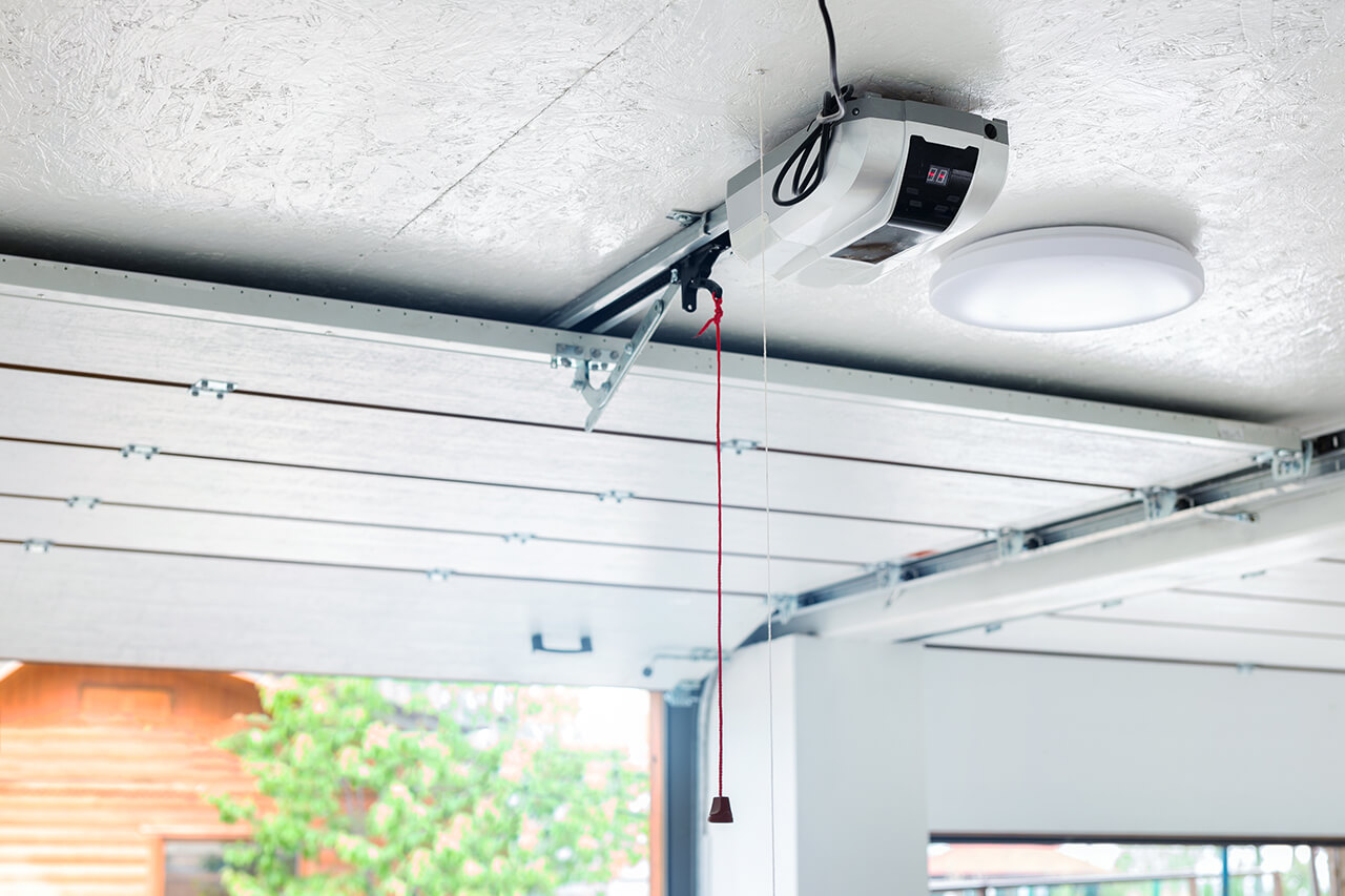 Technician servicing a garage door opener motor unit